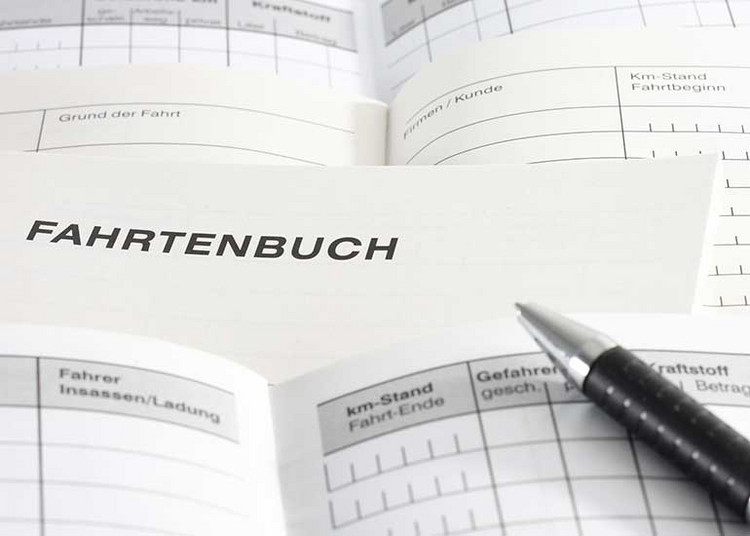 Zu sehen sind die aufgeschlagenen Seiten mehrerer Fahrtenbücher sowie ein Kugelschreiber.