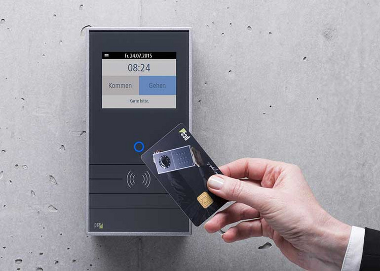 Eine Person hält eine Chipkarte vor ein Gerät zur Zeiterfassung.