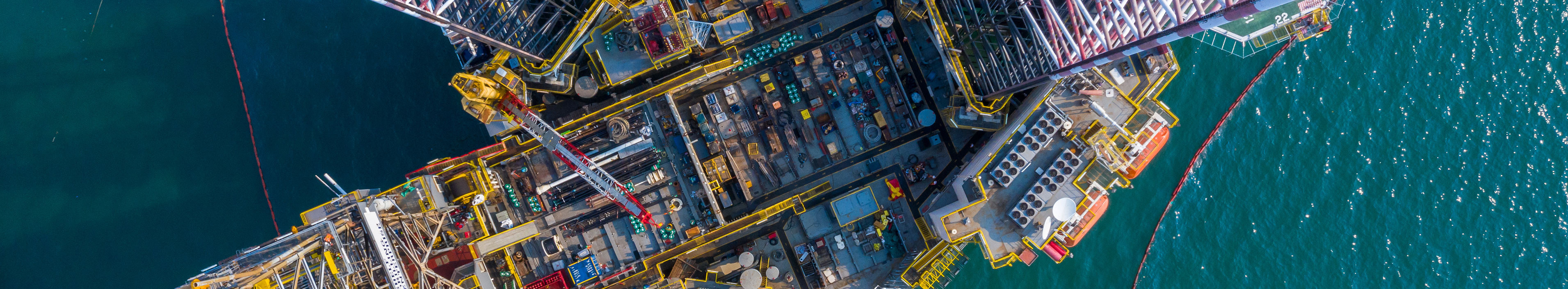 Blick auf eine Verladestation im Meer. Container und Kräne sind zu sehen.