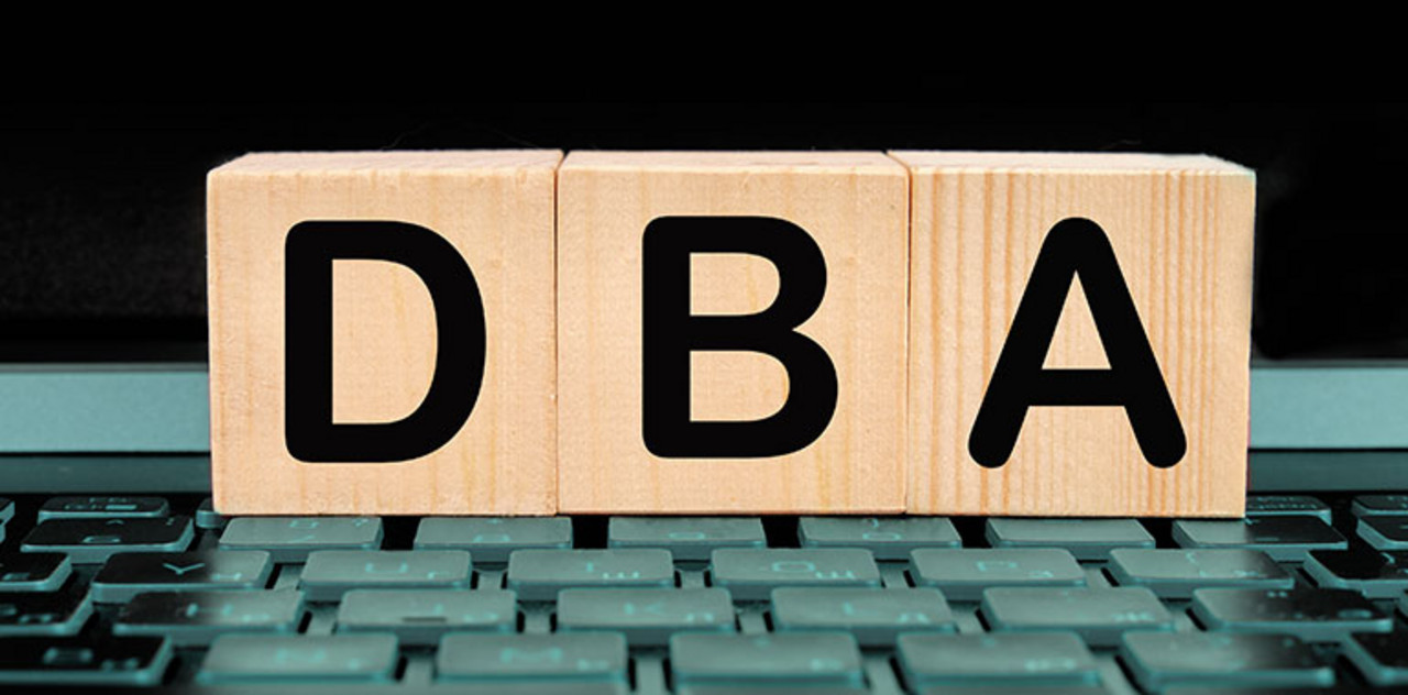 Auf 3 Holzklötzen steht "DBA" für “Doppelbesteuerungsabkommen”. Die Buchstaben stehen jeweils auf einem Holzklotz.