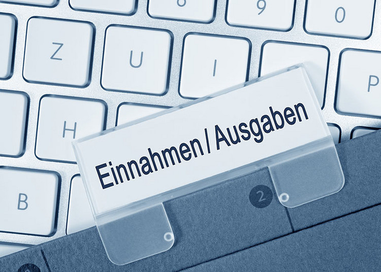 Auf einer Tastatur befindet sich ein Register mit der Aufschrift "Einnahmen/Ausgaben".