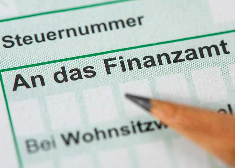 Zu sehen ist ein Ausschnitt aus einem Formular. Im Fokus steht der Text „An das Finanzamt“, auf den ein Stift zeigt.