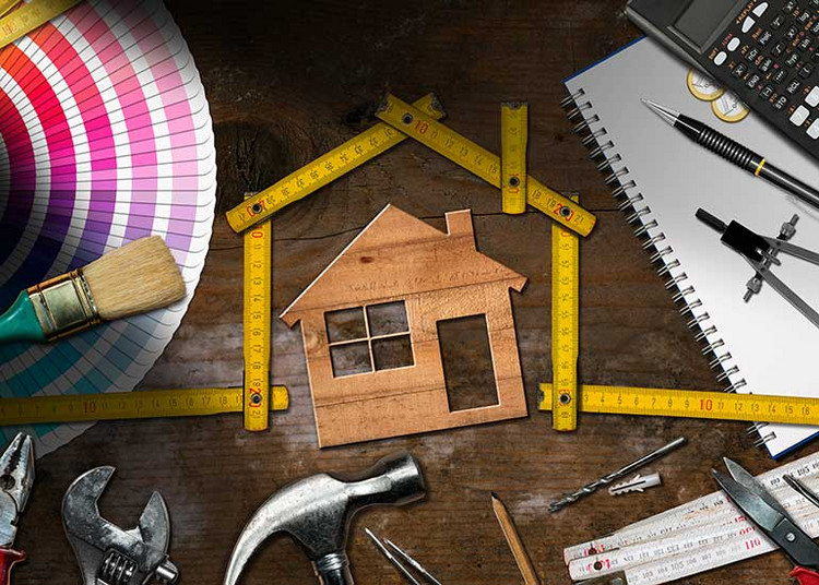 Um ein Modellhaus herum befindet sich ein Meterstab, ebenfalls in Form eines Hauses. Darum herum sind viele Werkzeuge wie Hammer, Zange, Pinsel sowie Farbwähler und Zirkel angeordnet.