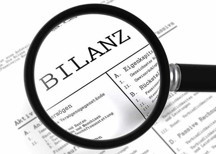 Fehlerhafte Rücklage muss korrigiert werden Eine Lupe vergrößert das Wort "Bilanz" auf einem Blatt Papier.