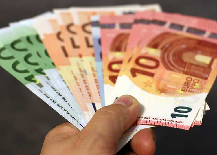 In einer Hand befinden sich viele Euro-Banknoten.