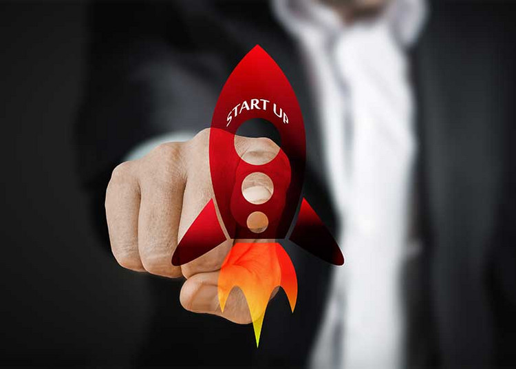 In der Bildcollage berührt eine Hand mit dem Zeigefinger eine Grafik einer Rakete, auf der der Schriftzug „Start Up” zu lesen ist.