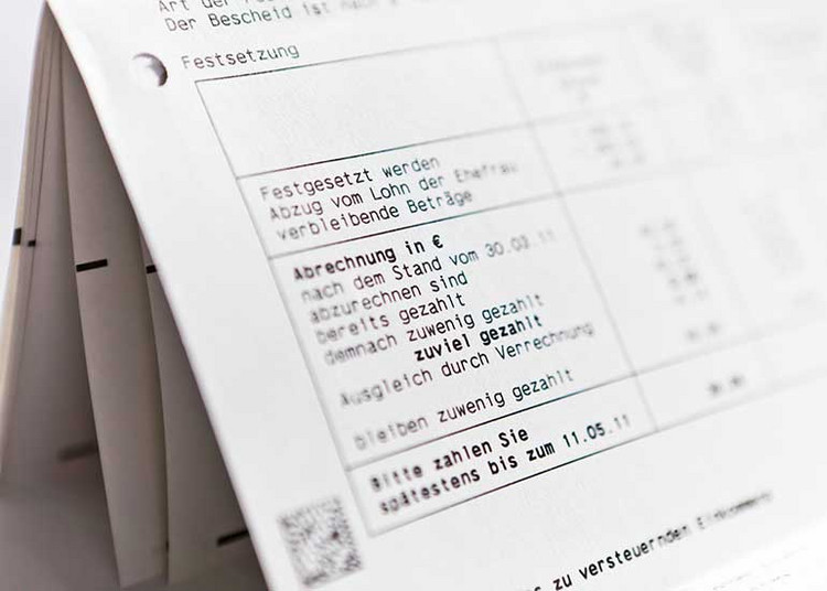 Steuerbescheid in Papierform mit Angaben zur Steuerabrechnung und Zahlungsaufforderung.