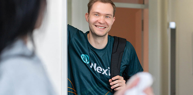Person wartet auf Kollegin mit Nexia Sportshirt.