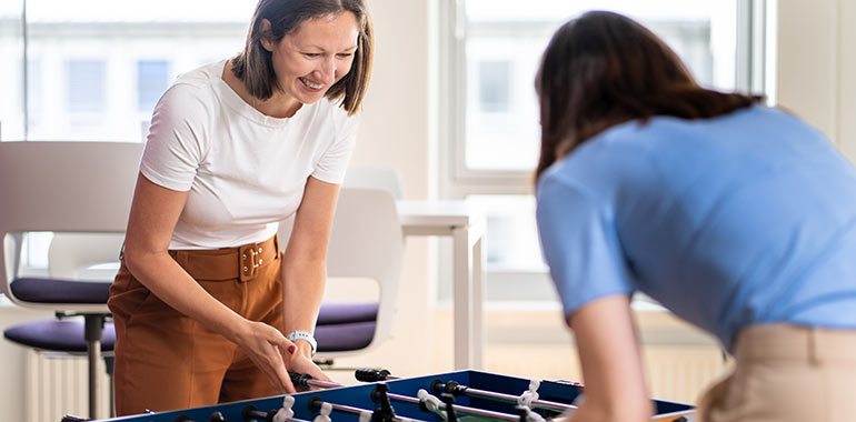 Zwei Personen spielen Tischfußball.