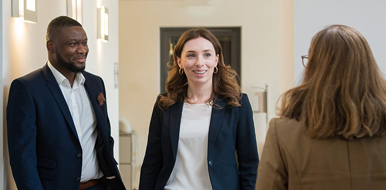 Drei Personen treffen sich im Flur des Nexia-Büros.