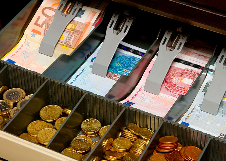 Blick in eine Registrierkasse. Sie ist mit Euro-Banknoten und -Münzen gefüllt.