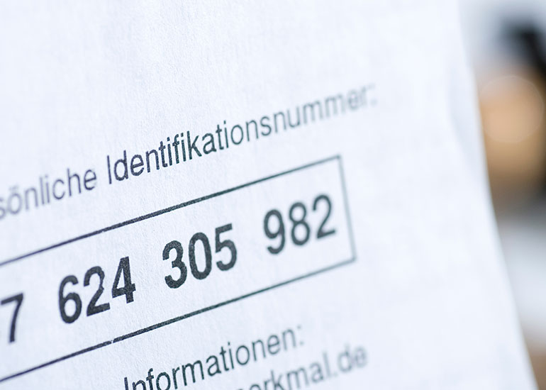 Detailansicht einer persönlichen Identifikationsnummer auf einem Blatt Papier.