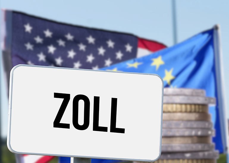 Ein Schild mit der Aufschrift "Zoll" steht vor einer amerikanischen und einer europäischen Flagge. Außerdem ist ein Münzstapel abgebildet.