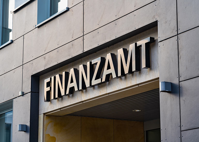 Detailansicht des Schildes "Finanzamt" an einem Gebäude.