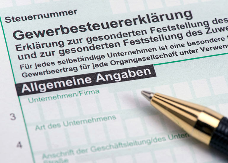 Ein Kugelschreiber liegt auf einer Gewerbesteuererklärung.