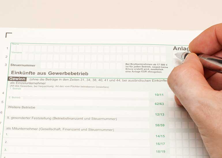 Eine Person füllt das Formular „Einkünfte aus Gewerbebetrieb” aus.