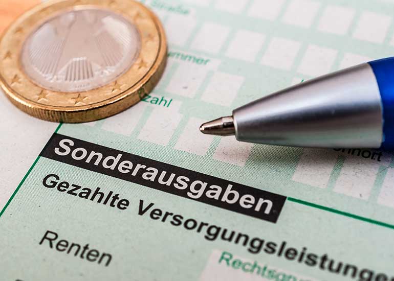 Zu sehen ist ein Ausschnitt aus einem Steuerformular mit dem Abschnitt „Sonderausgaben”. Darauf liegen eine Euro-Münze und ein Kugelschreiber.
