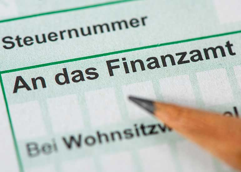 Zu sehen ist ein Ausschnitt aus einem Formular. Im Fokus steht der Text „An das Finanzamt“, auf den ein Stift zeigt.