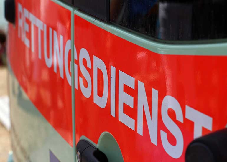Die Detailansicht zeigt die Seite eines Rettungsfahrzeuges, wobei die Perspektive von der Seite aus aufgenommen wurde.