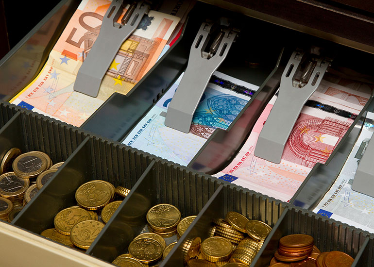 Blick in eine Registrierkasse. Sie ist mit Euro-Banknoten und -Münzen gefüllt.