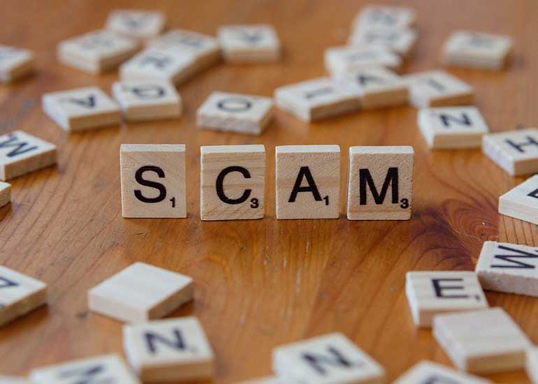 Der Begriff „Scam” ist aus Spielsteinen geschrieben.