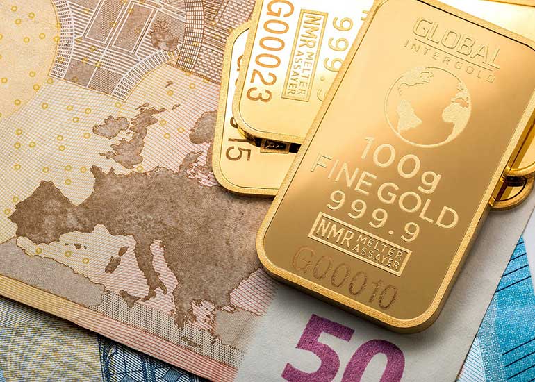 Goldbarren liegen auf Euro-Banknoten.