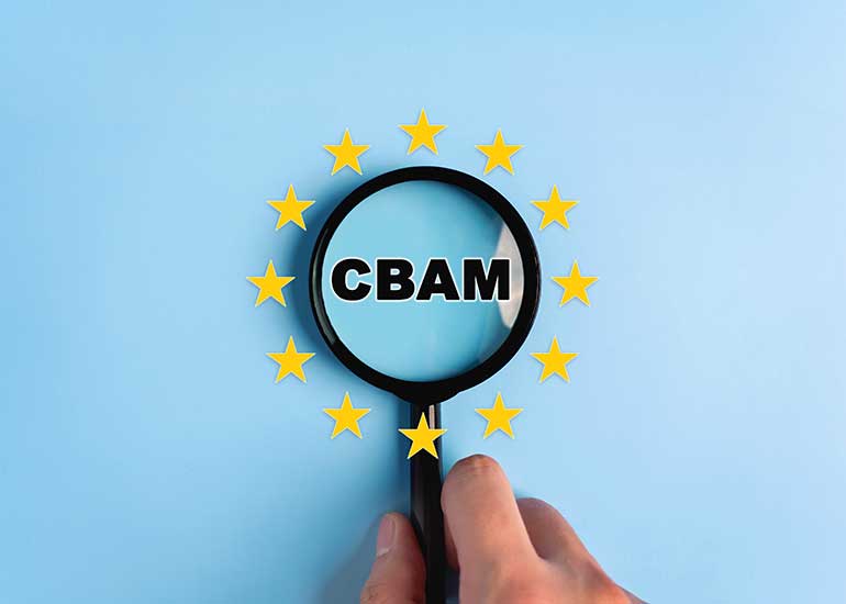 Eine Hand hält eine Lupe, durch die der Begriff „CBAM” vergrößert wird. Um die Lupe herum sind Sterne angeordnet, die Europa symbolisieren sollen.