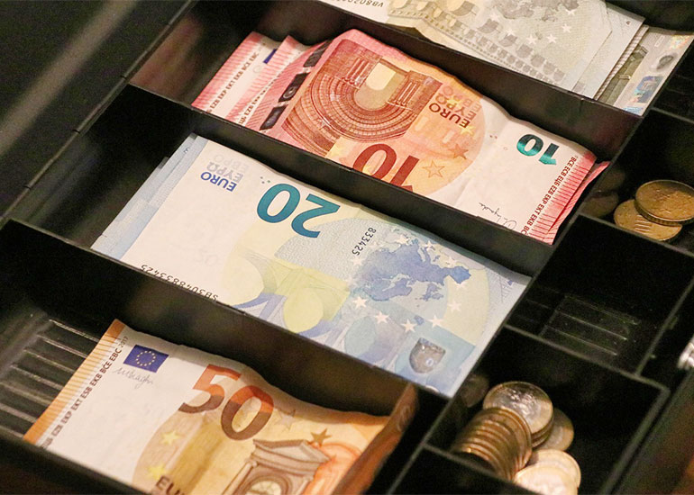 Das Foto zeigt Euro-Banknoten in einer Registrierkasse.