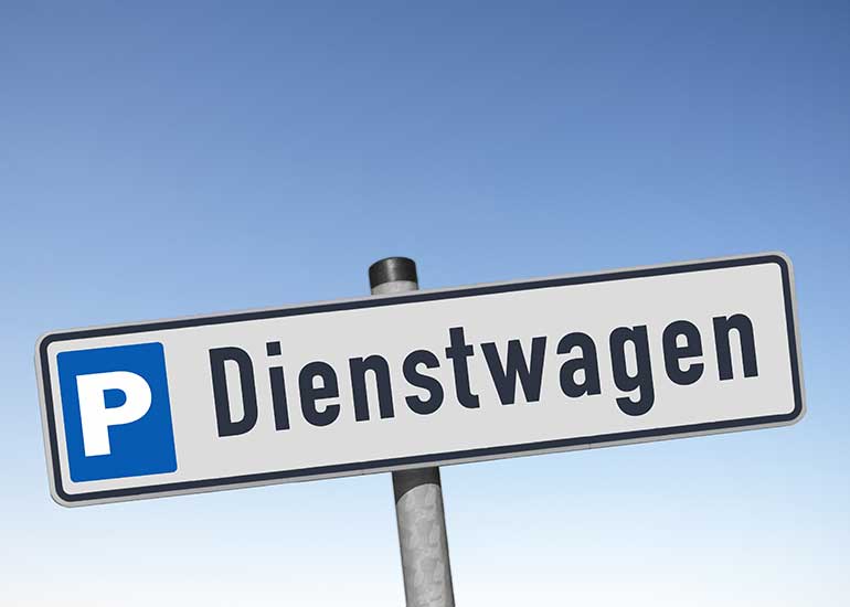 Auf einem Schild sind ein Parksymbol und die Aufschrift „Dienstwagen” zu sehen.