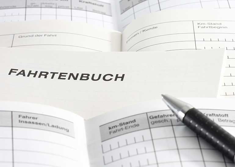 Zu sehen sind die aufgeschlagenen Seiten mehrerer Fahrtenbücher sowie ein Kugelschreiber.