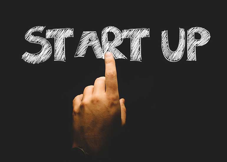 Die Bildcollage zeigt eine Hand, die mit dem Zeigefinger einen virtuellen Schriftzug berührt. Darauf ist „Start Up“ zu lesen.