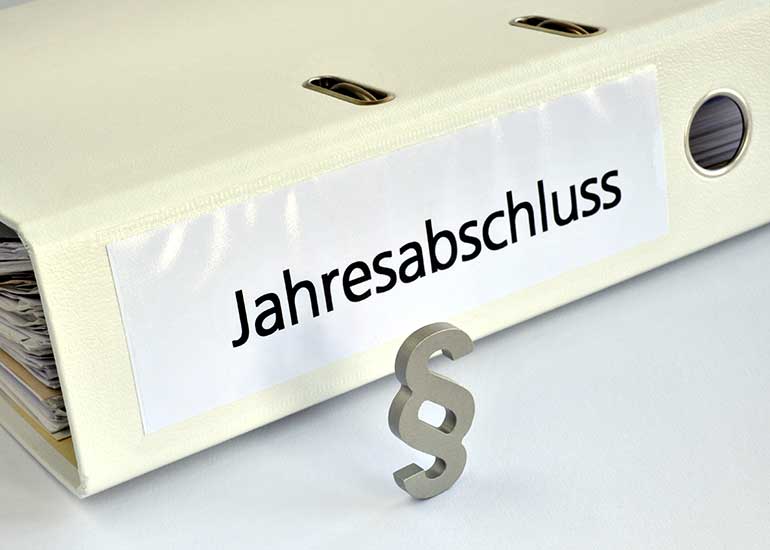 Aktenordner mit der Aufschrift „Jahresabschluss“ sowie einem Paragraphenzeichen als Symbol für die gesetzlichen Vorgaben der Rechnungslegung und Bilanzierung.