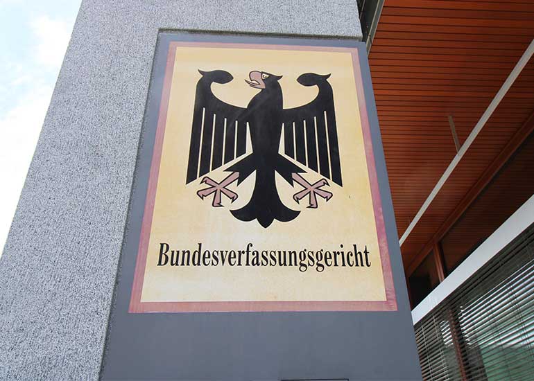Schild des Bundesverfassungsgerichts mit Bundesadler an der Außenfassade eines Gebäudes.