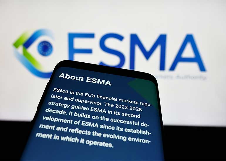 Im Hintergrund ist das Logo der ESMA (Europäische Wertpapier- und Marktaufsichtsbehörde) zu sehen, im Vordergrund ein Handy mit einem Text, der kurz zusammenfasst, was die ESMA macht.